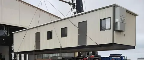 A modular building lifted into place by crane